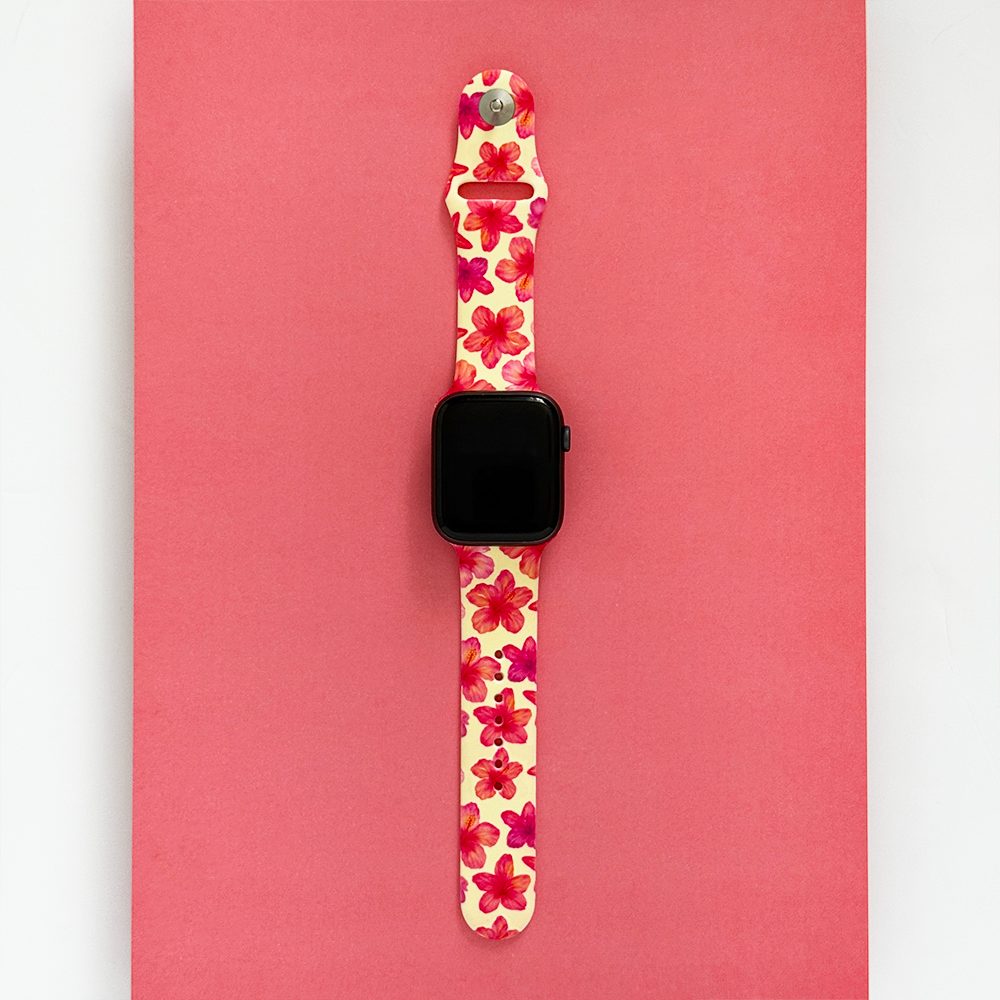 Butter yellow Apple Watch strap with hibiscus print by Coconut Lane on a pink background.