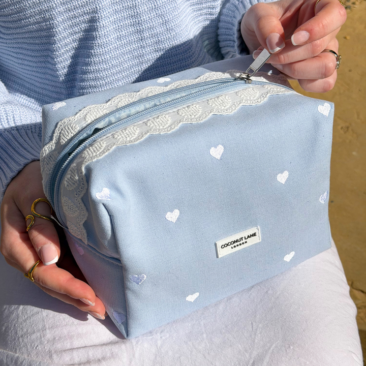 Close up image of the Blue Hearts Makeup Bag on girls lap 