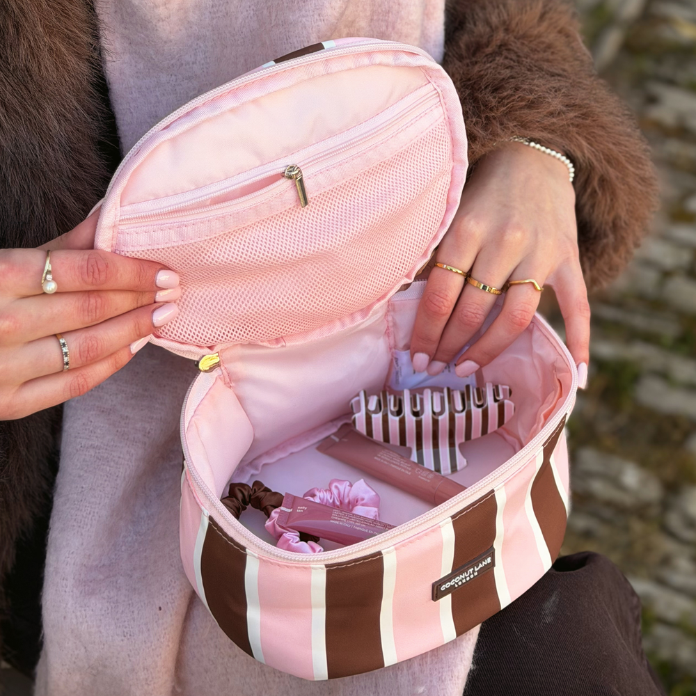 Close-up image of the interior of the coconut Lane Cocoa & Pink Stripe round vanity makeup bag with inside pocket details.
