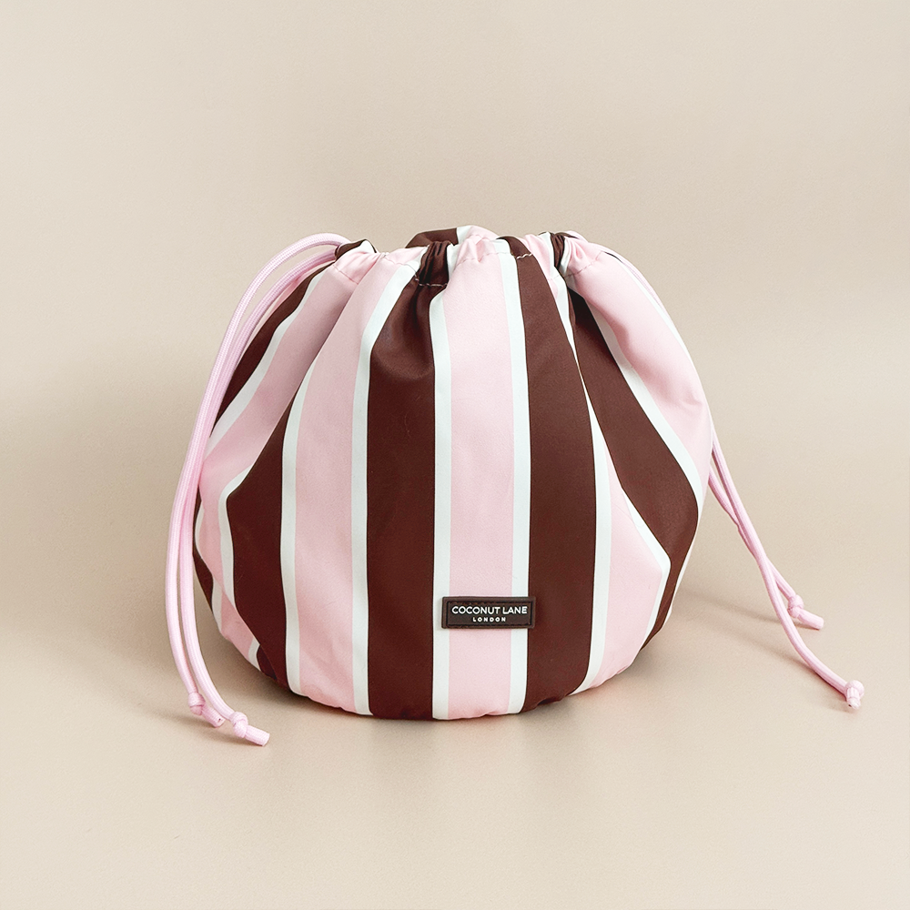 Coconut Lane Cocoa & Pink Stripe drawstring toiletry bag featuring chocolate brown, baby pink and white stripes with pink drawstring closure.