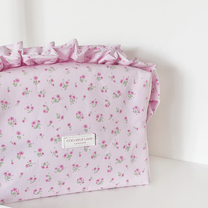 Pink floral Makeup Bag with ruffle trim and Coconut Lane logo.