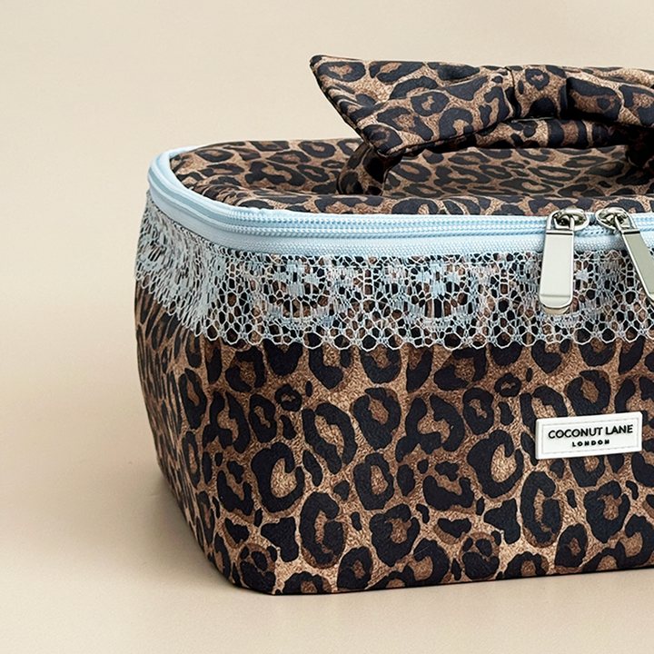 Close-up of Coconut Lane Leopard Lace vanity case showing brown leopard print fabric, baby blue lace trim and matching zip fastening.
