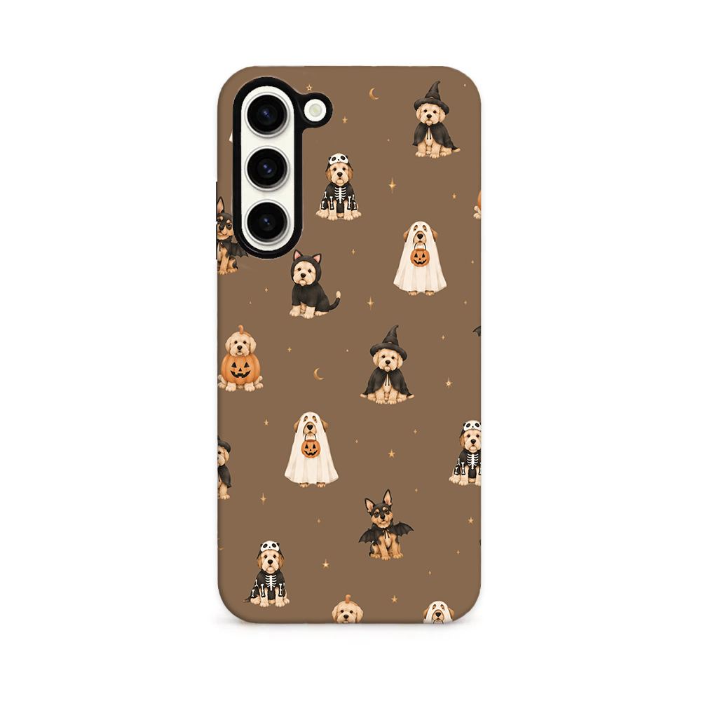 Pups wearing spooky outfits on a brown background.