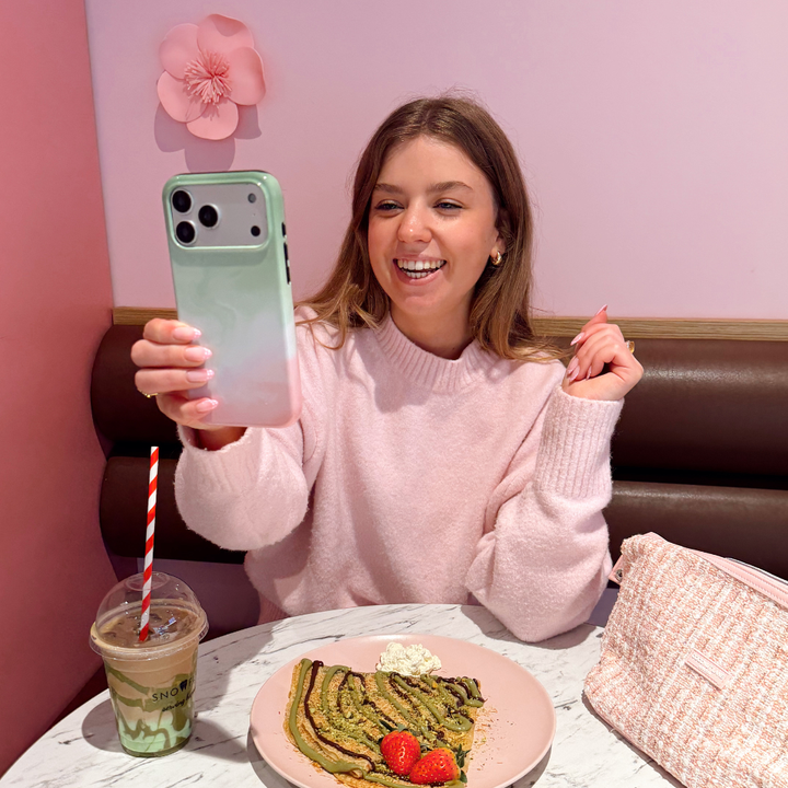 Girl smiling holding the Tough Strawberry Matcha Phone Case