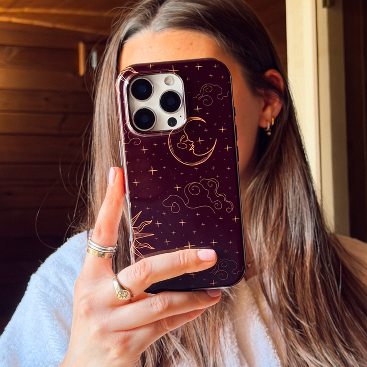 Girl in dressing gown holding tough celestial phone case