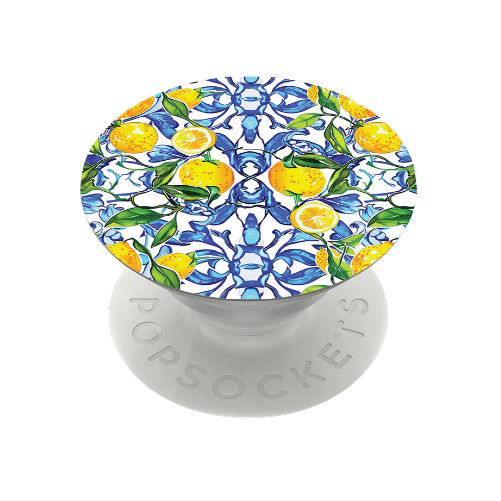 The Coconut Lane PopSocket Grip - Amalfi Lemon features a vibrant design of lemons and green leaves against a white and blue patterned background. It has a white base embossed with "PopSockets." This accessory seamlessly combines intricate natural elements with geometric shapes, adding style without interfering with wireless charging.
