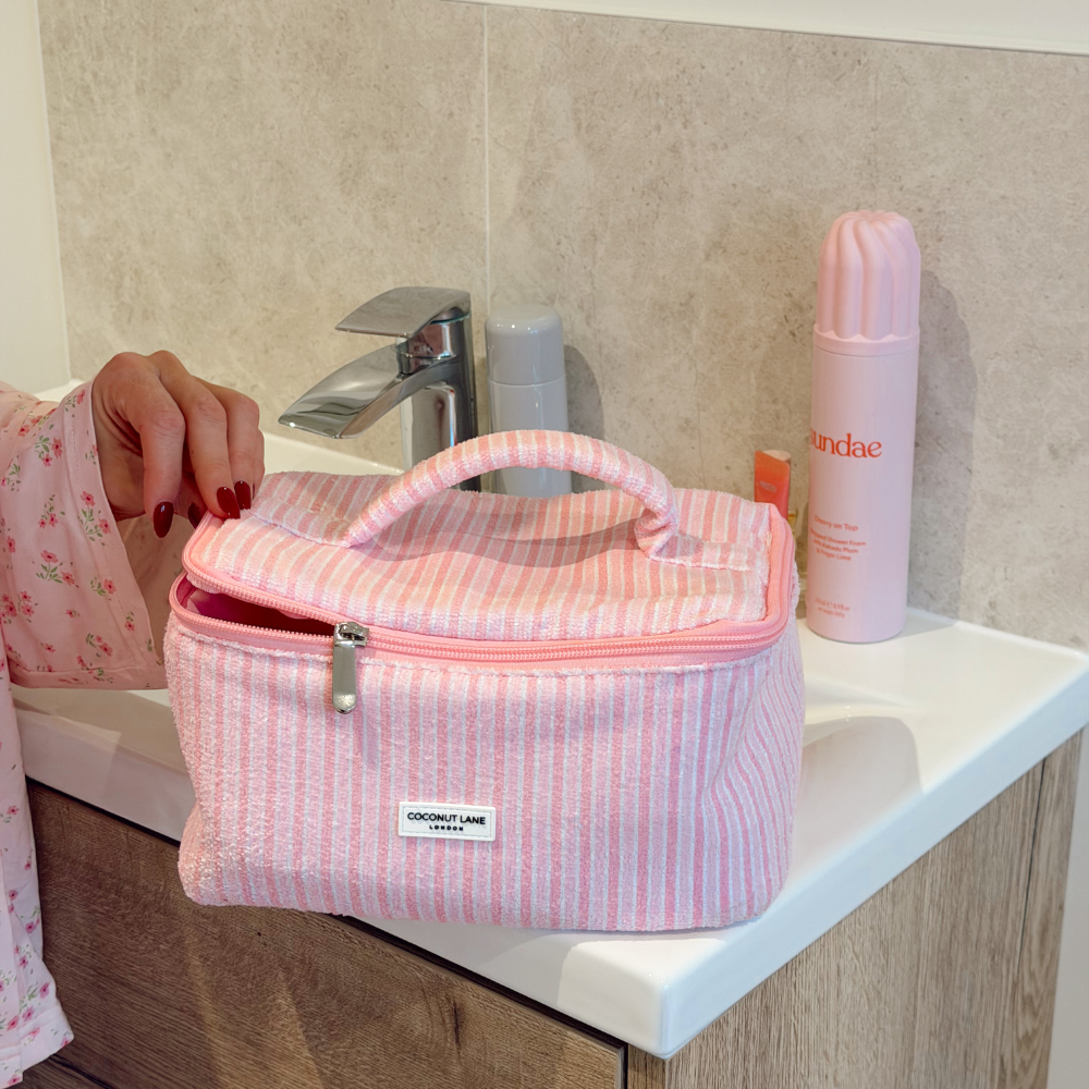 Girl opening Powder Stripes Vanity Case on bathroom sink