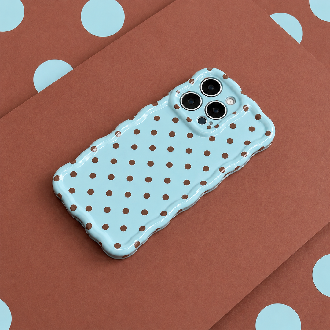 Blue polka dot phone case on a brown surface with blue polka dots.