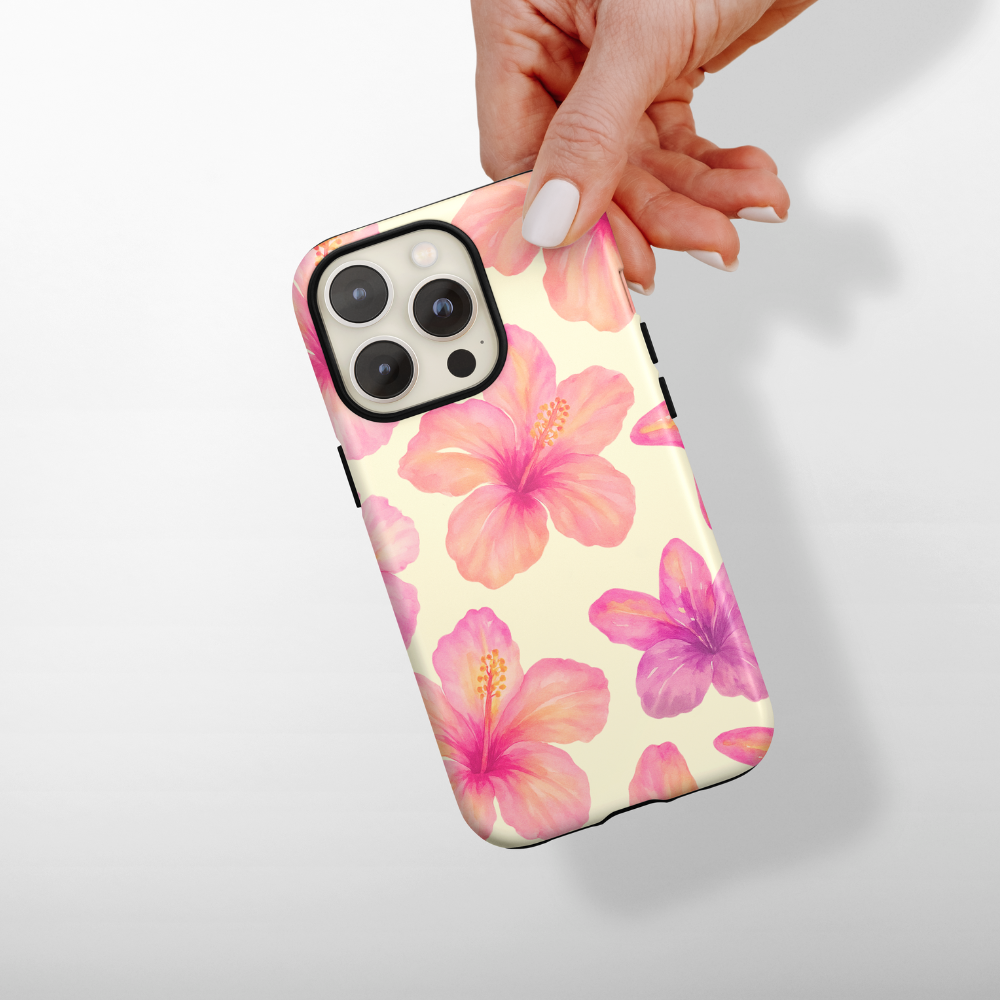Hand holding a yellow phone case with pink and purple hibiscus floral pattern.