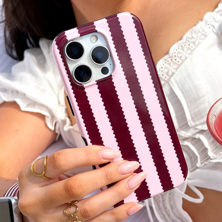 Girl holding a Blushberry scallop stripe phone case by the pool