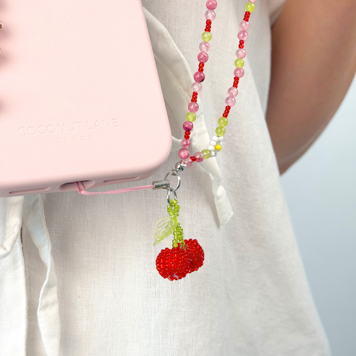 beaded cherry bomb phone strap attached to pink phone case